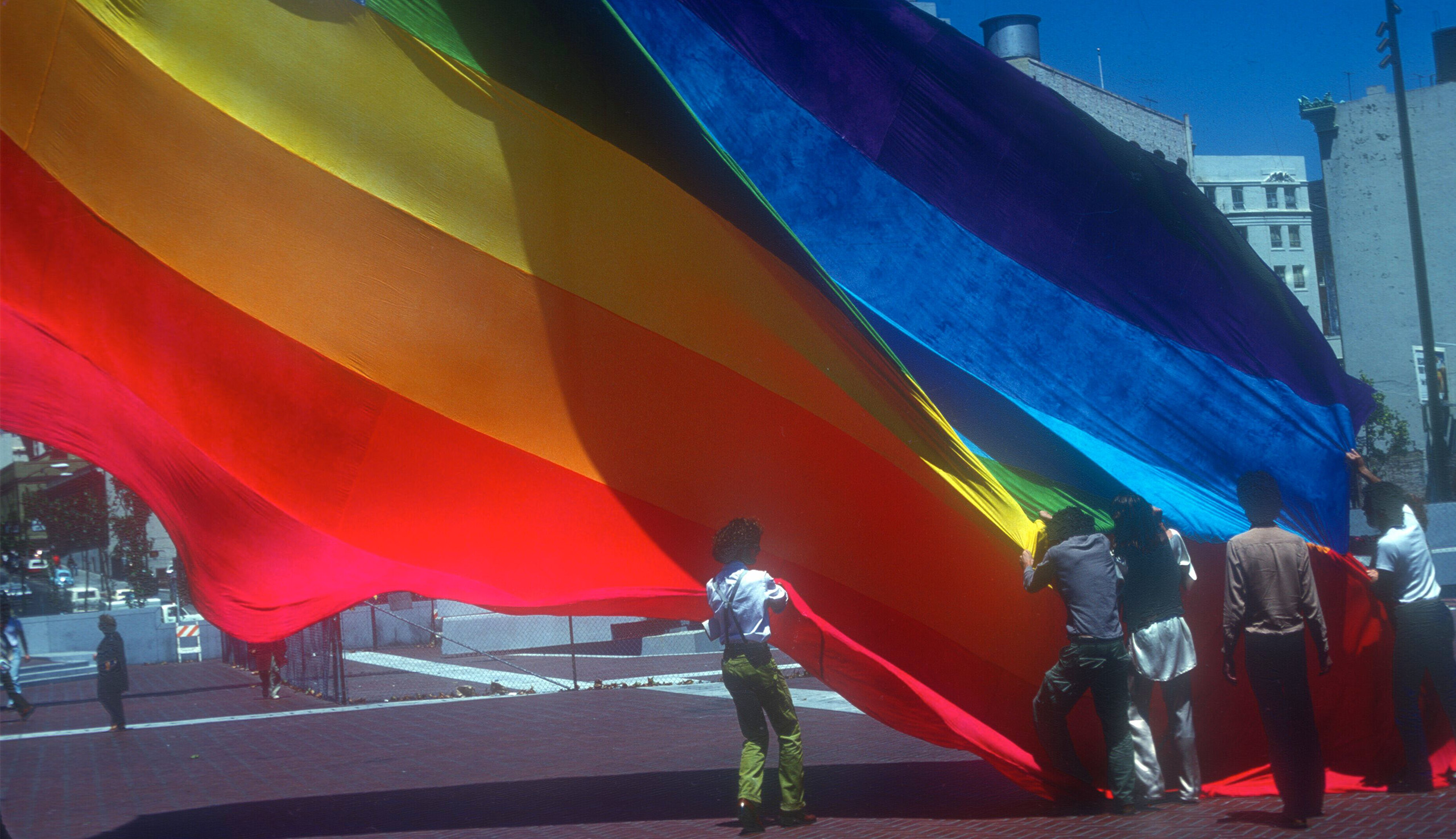 Gilbert Baker and volunteers raising the original Pride flag in San Francisco’s United Nations Plaza in 1978