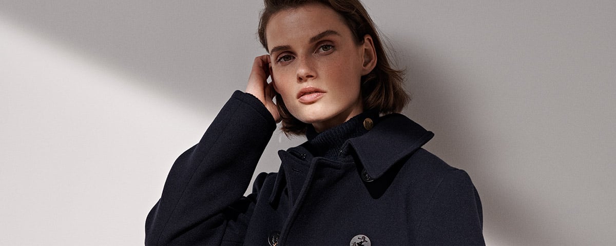 Woman in peacoat with anchor buttons